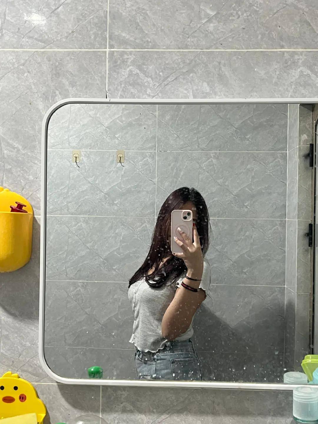 Man wearing a gray tank top with a design on the back, standing outdoors View 2